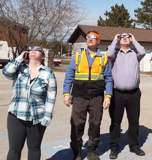 staff look up at the solar eclipse